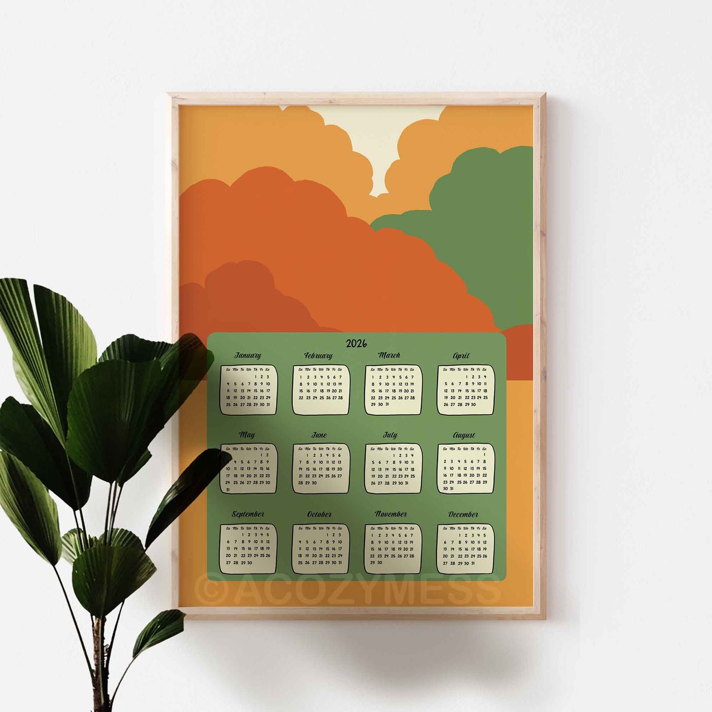 Framed calendar with autumn-themed design on a white wall