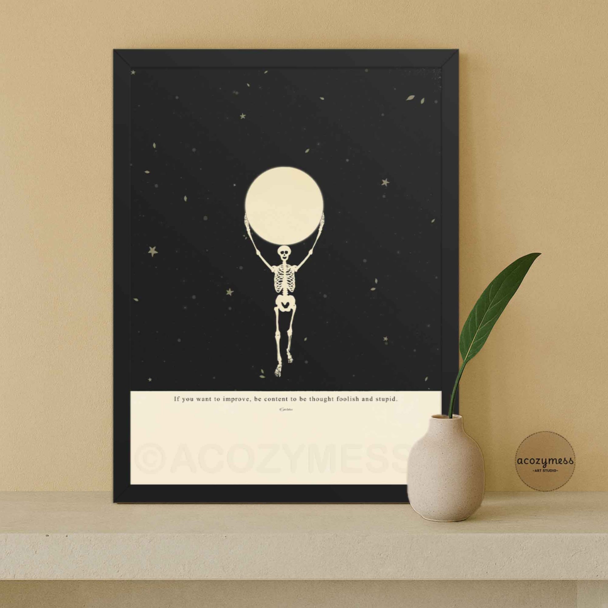 Framed Epictetus quote wall art with skeleton holding the moon illustration on a starry black and beige background, set in a modern black wood frame, ready-to-hang stoic philosophy decor