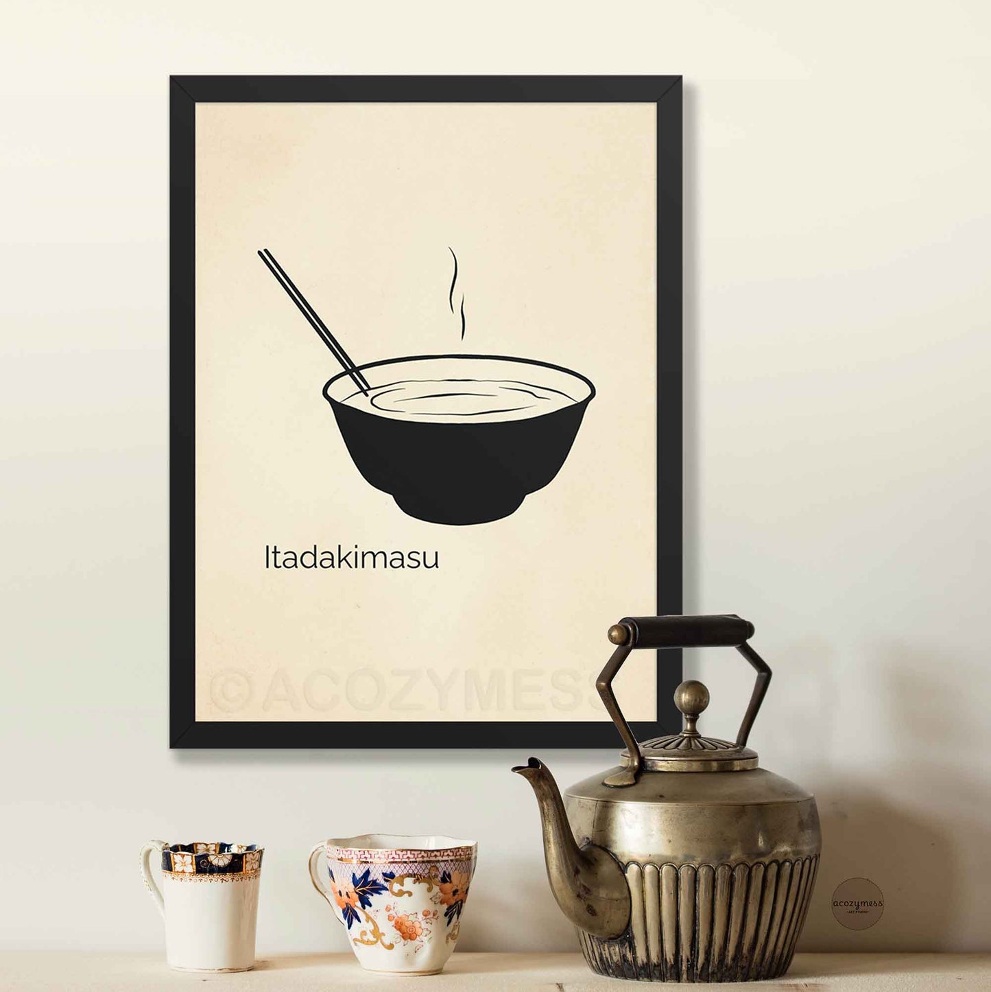 Framed artwork of a bowl with chopsticks and 'Itadakimasu' text on a beige background.