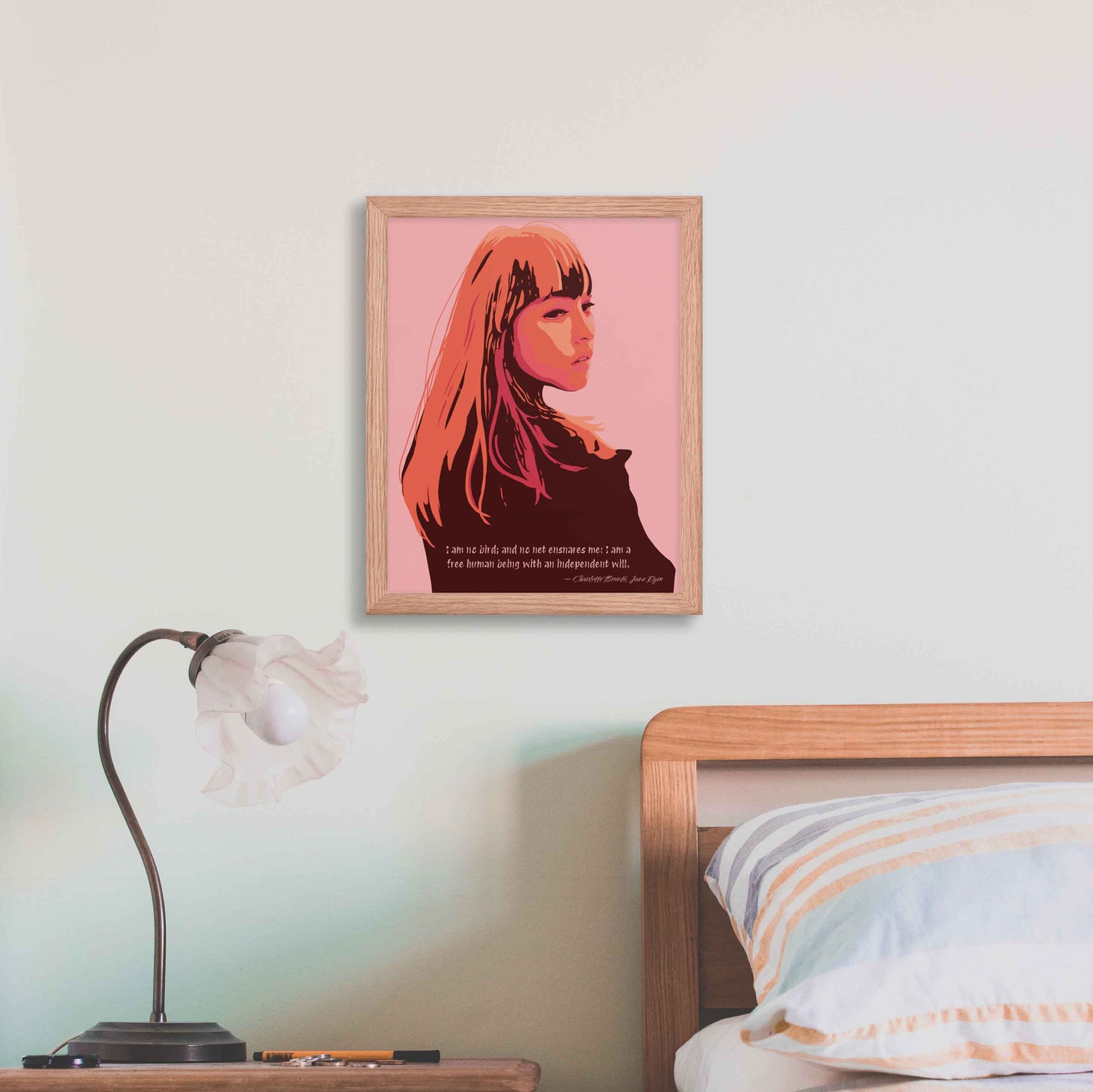 Art print of a woman in pink, orange, and brown tones with a quote from Jane Eyre reading 'I am no bird; and no net ensnares me; I am a free human being, with an independent will,' in 11x14 oakwood frame