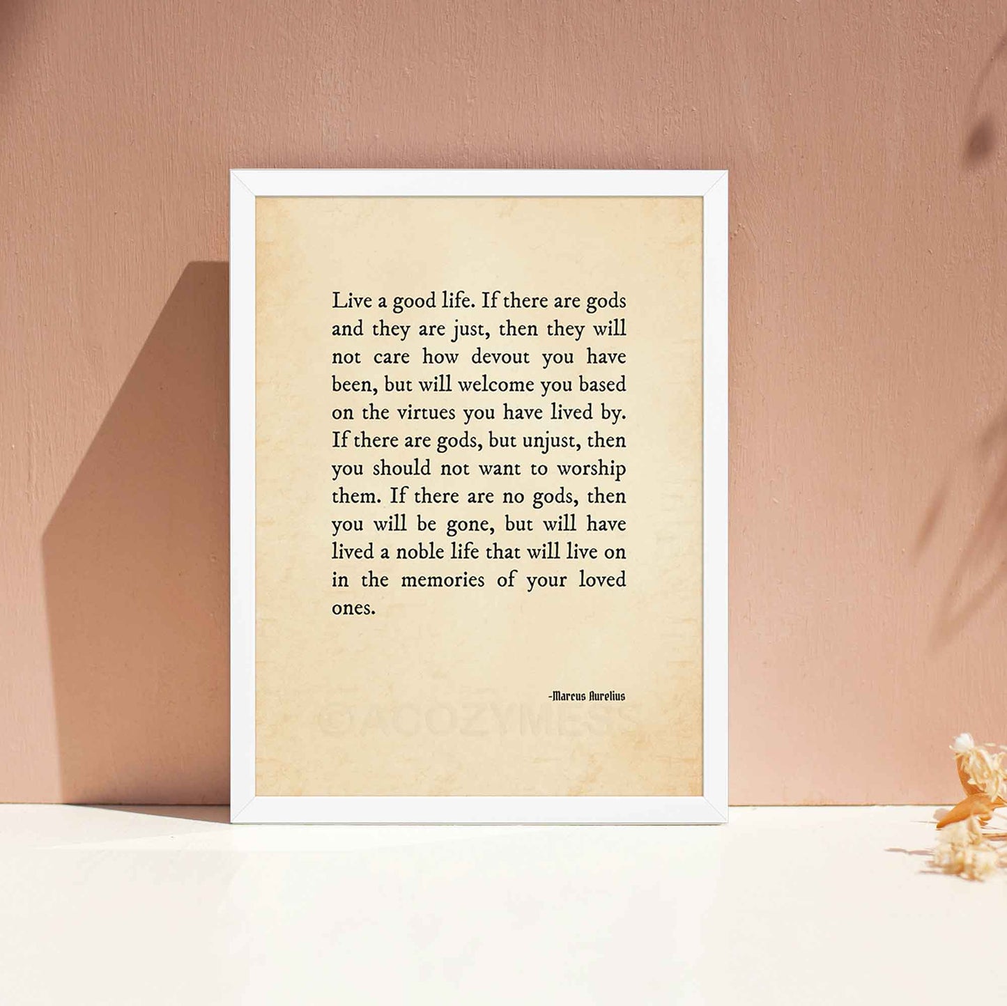 Marcus Aurelius Quote on god and good life, black on old style paper texture, displayed in white frame.