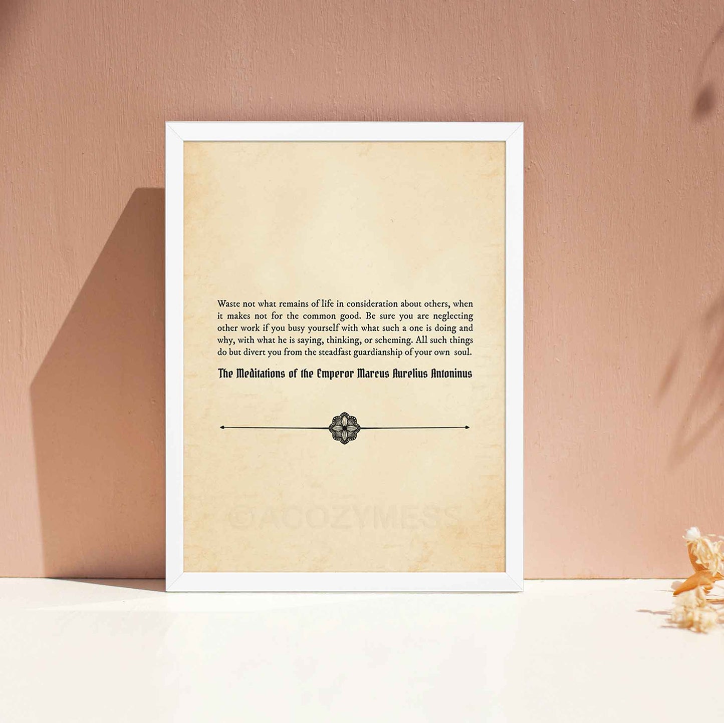 A vintage-style poster featuring a Marcus Aurelius quote on an aged book paper background in white frame.