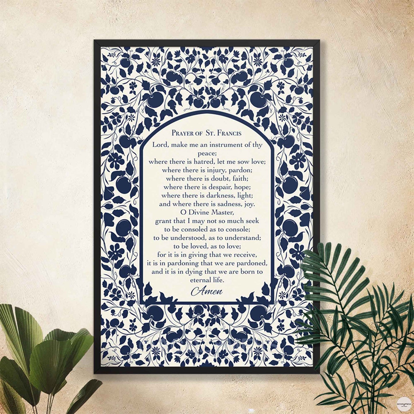 Prayer of St. Francis wall art displayed in a sleek black frame, featuring a floral design in dark blue on light beige background.