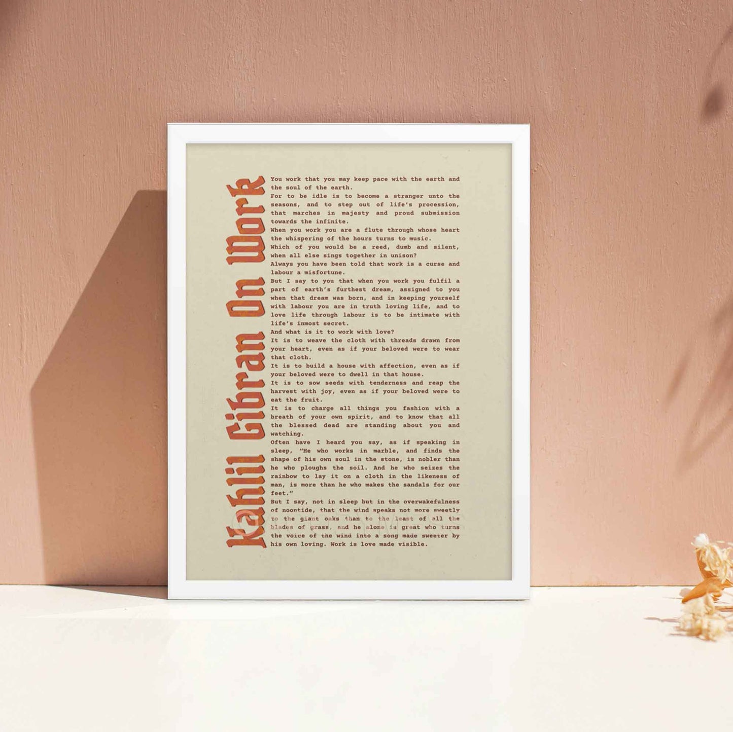 Work motivational print by Kahlil Gibran in white frame.