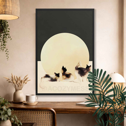 Framed artwork of three cats under a moonlit sky on a wall above a wooden console table.