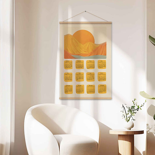 2025 illustrated calendar featuring a serene nature scene in yellow and orange tones, displayed with an oakwood hanger in a living room, perfect for adding warmth and charm.