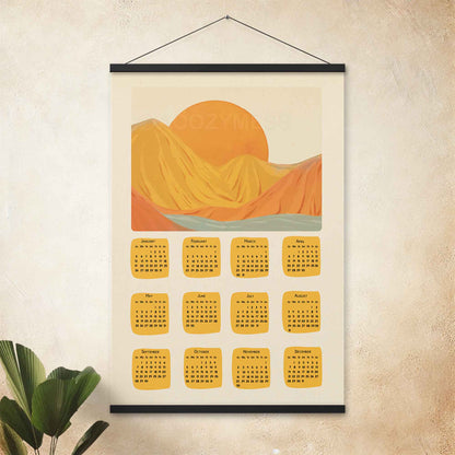 2025 illustrated calendar featuring a serene nature scene in yellow and orange tones, displayed with an black hanger on a entryway wall, perfect for adding warmth and charm.
