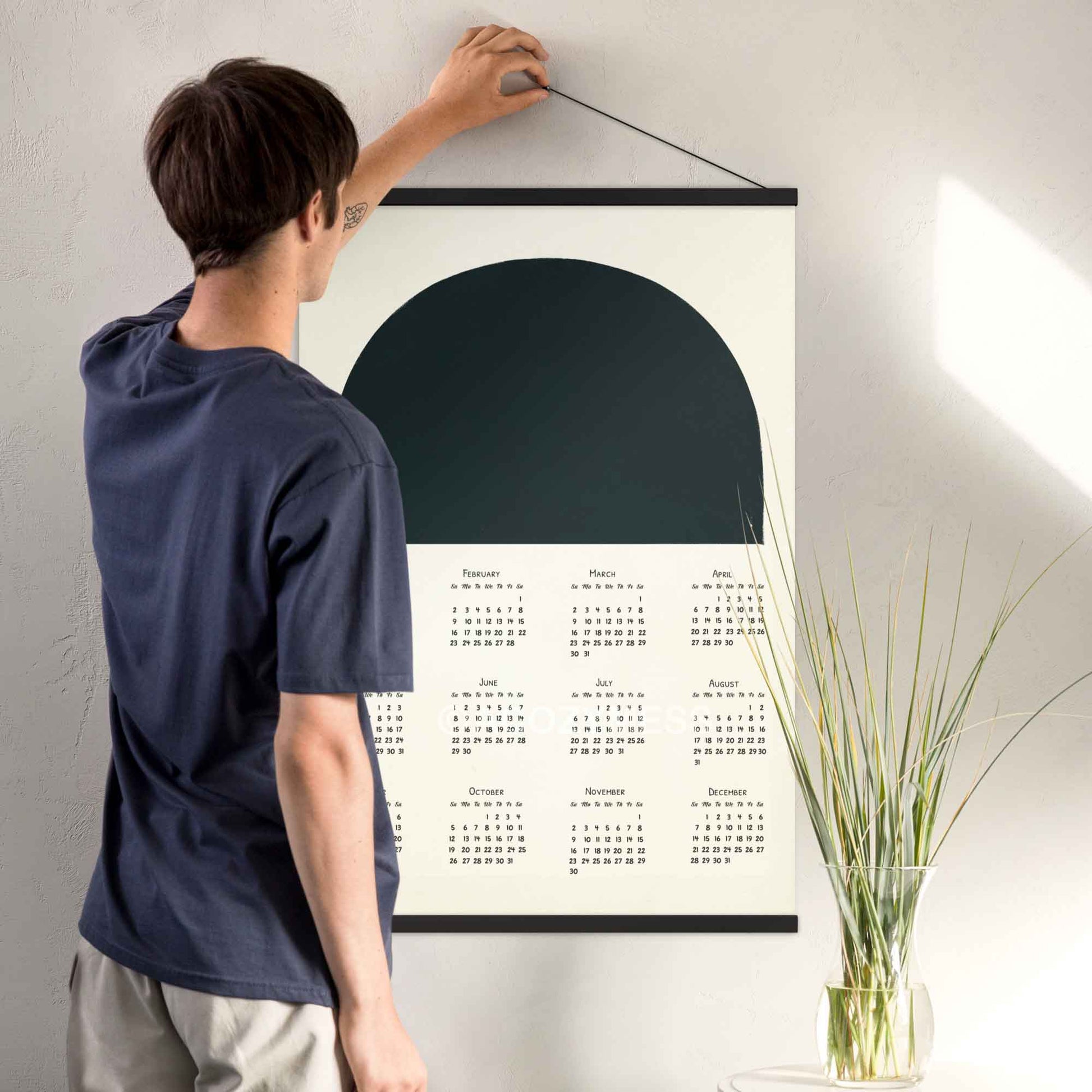 2025 yearly calendar poster with minimalist black and white design,  with black hanger, perfect for modern home or office decor.