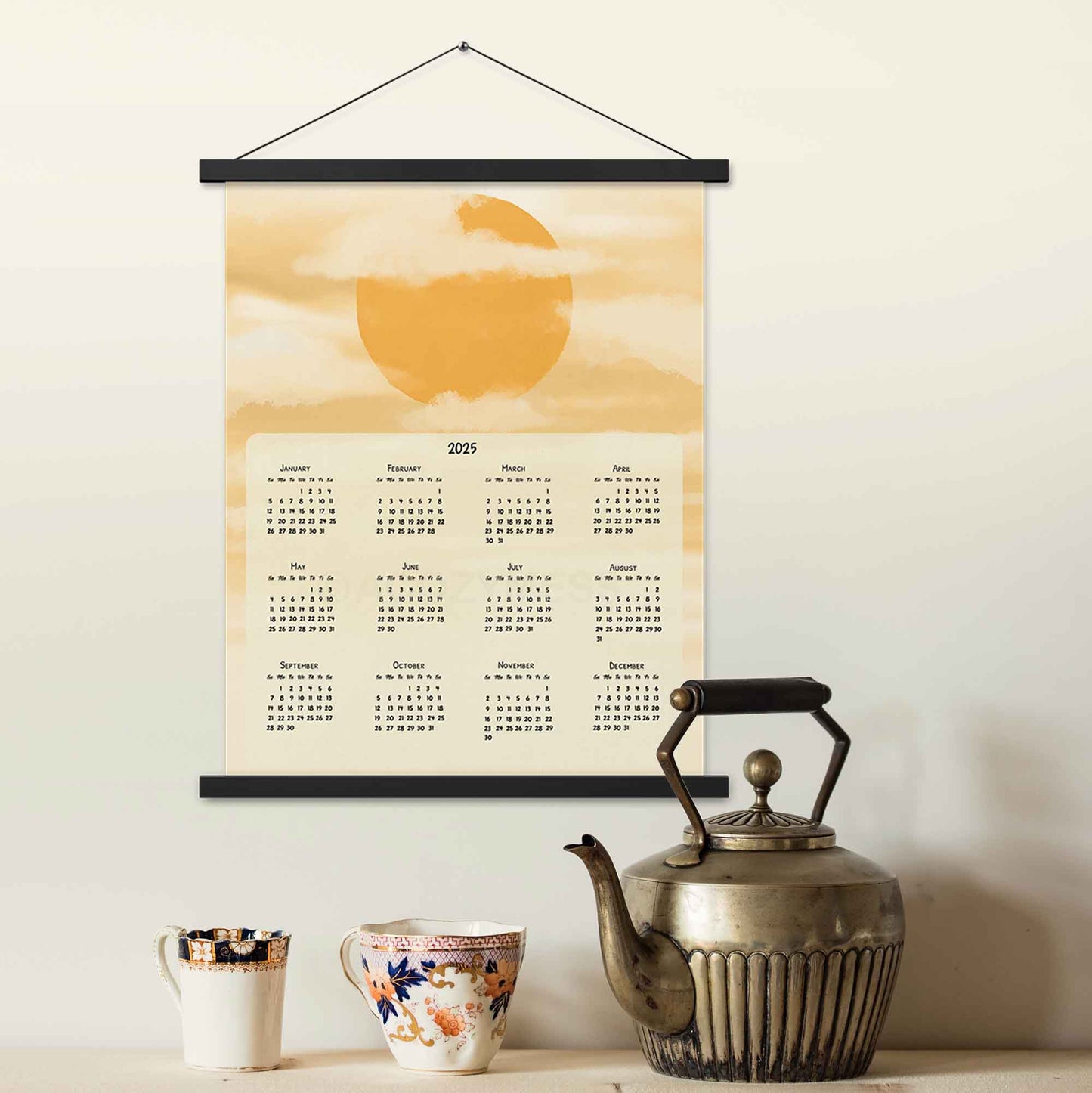 2025 yearly wall calendar featuring a sun and clouds illustration on a muted yellow background, adding warmth to the design, displayed in a black hanger frame.