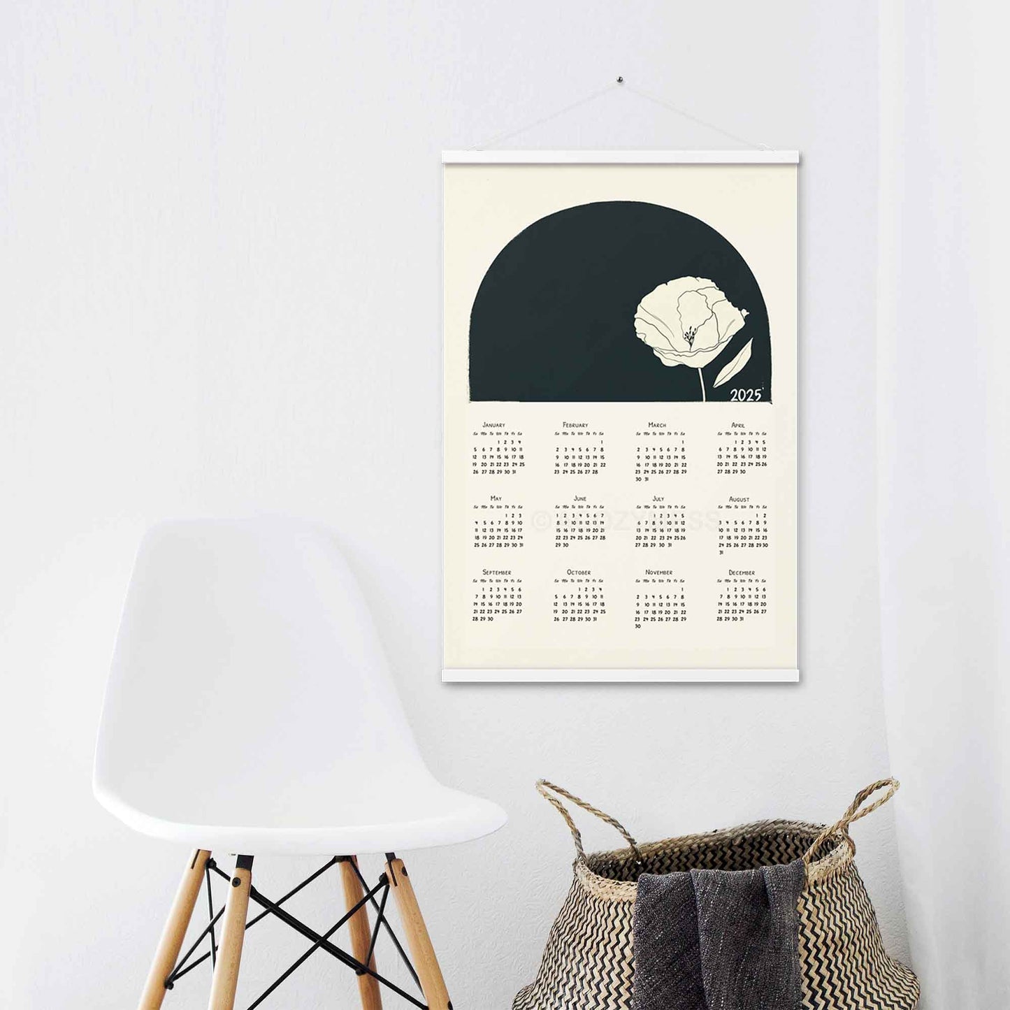 2025 calendar for wall with minimalist design, with white hanger, on a laundry room wall.