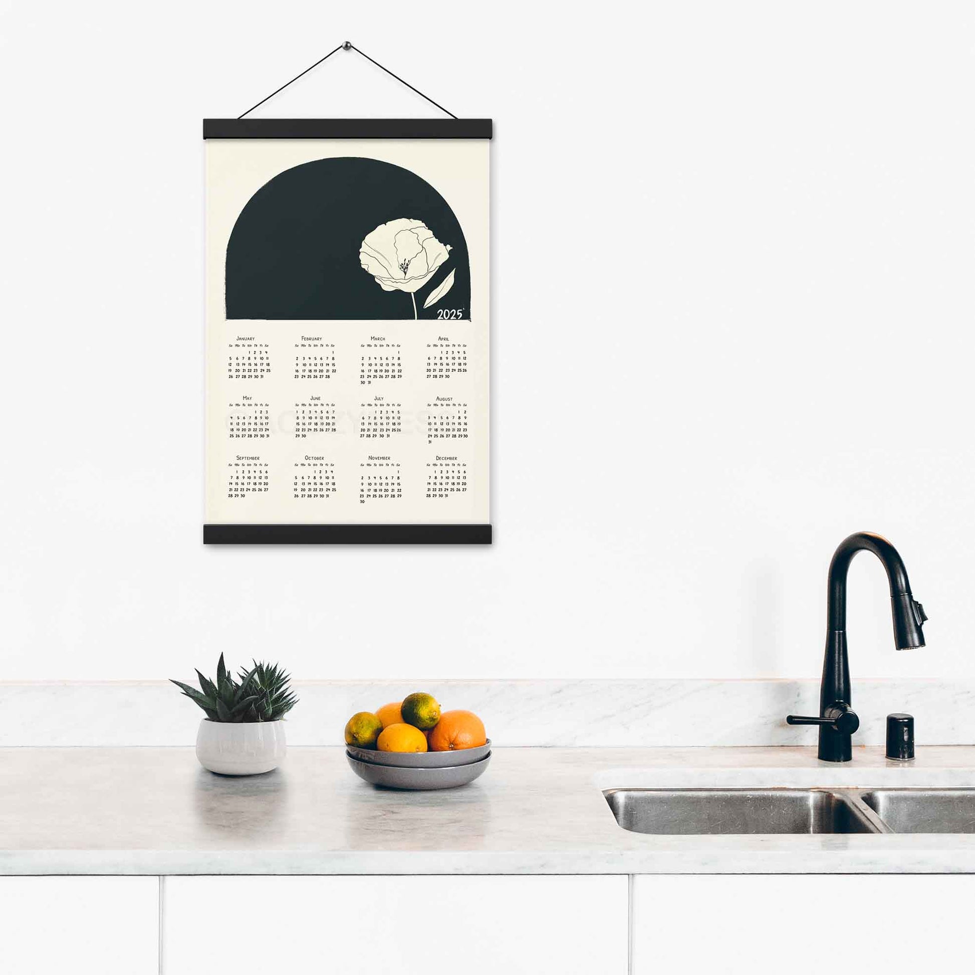 2025 yearly calendar poster with minimalist design, with black hanger, on kitchen wall