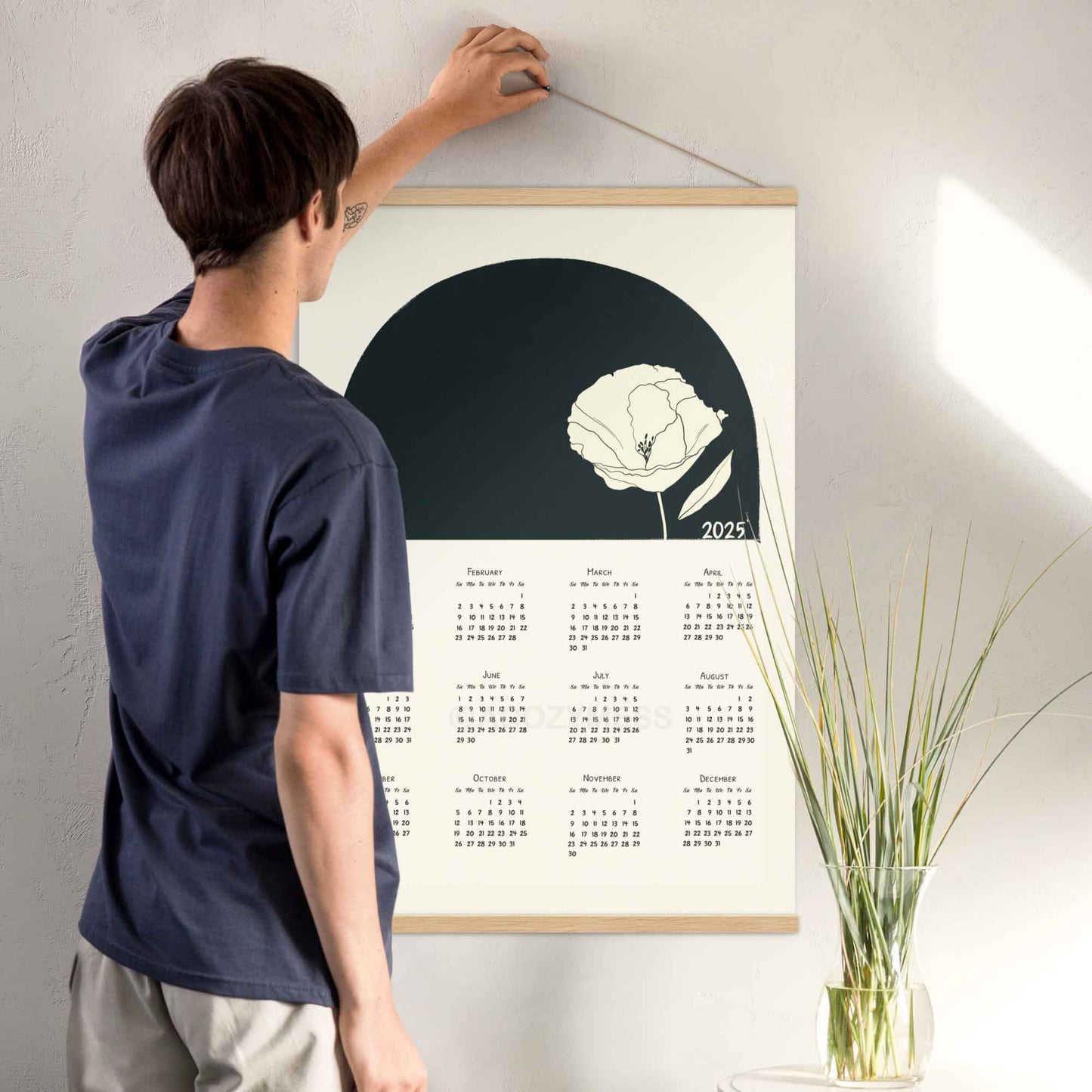 2025 yearly calendar poster with minimalist design, with oakwood hanger, perfect for modern home or office decor.