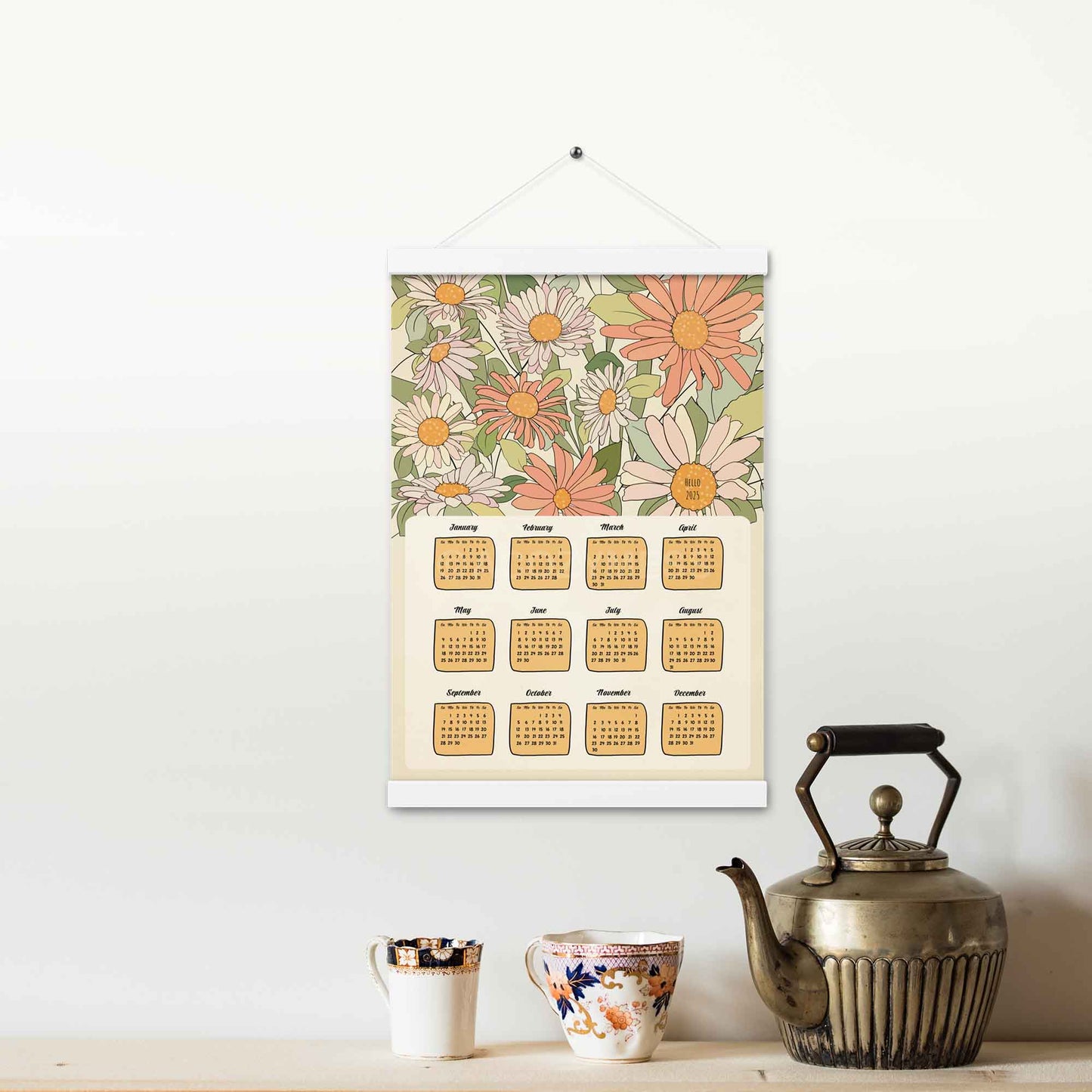 Illustrated 2025 calendar with floral design in beige, green, pink, and orange colors, featuring an white hanger. 