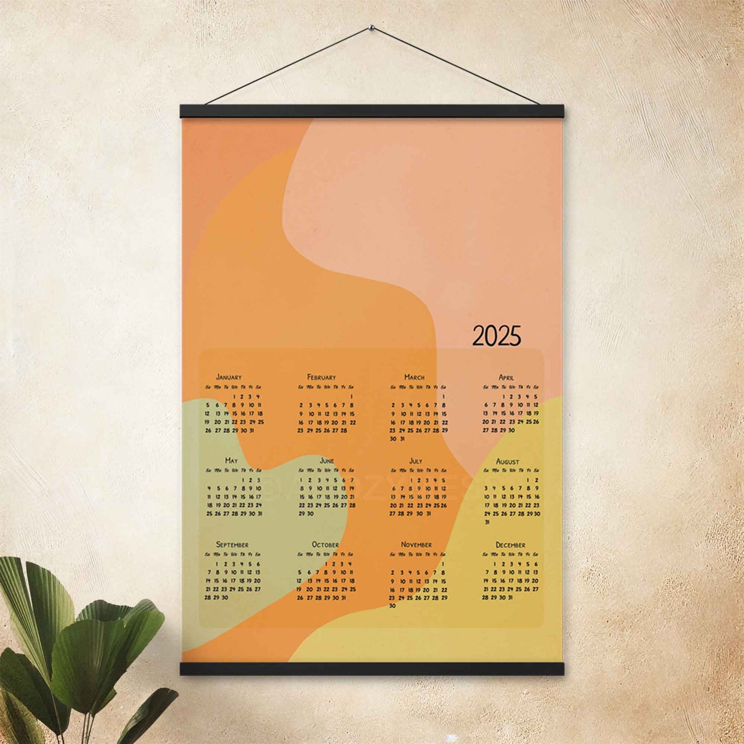 2025 yearly calendar poster with an abstract design in pastel colors, displayed with an black hanger on an office wall.