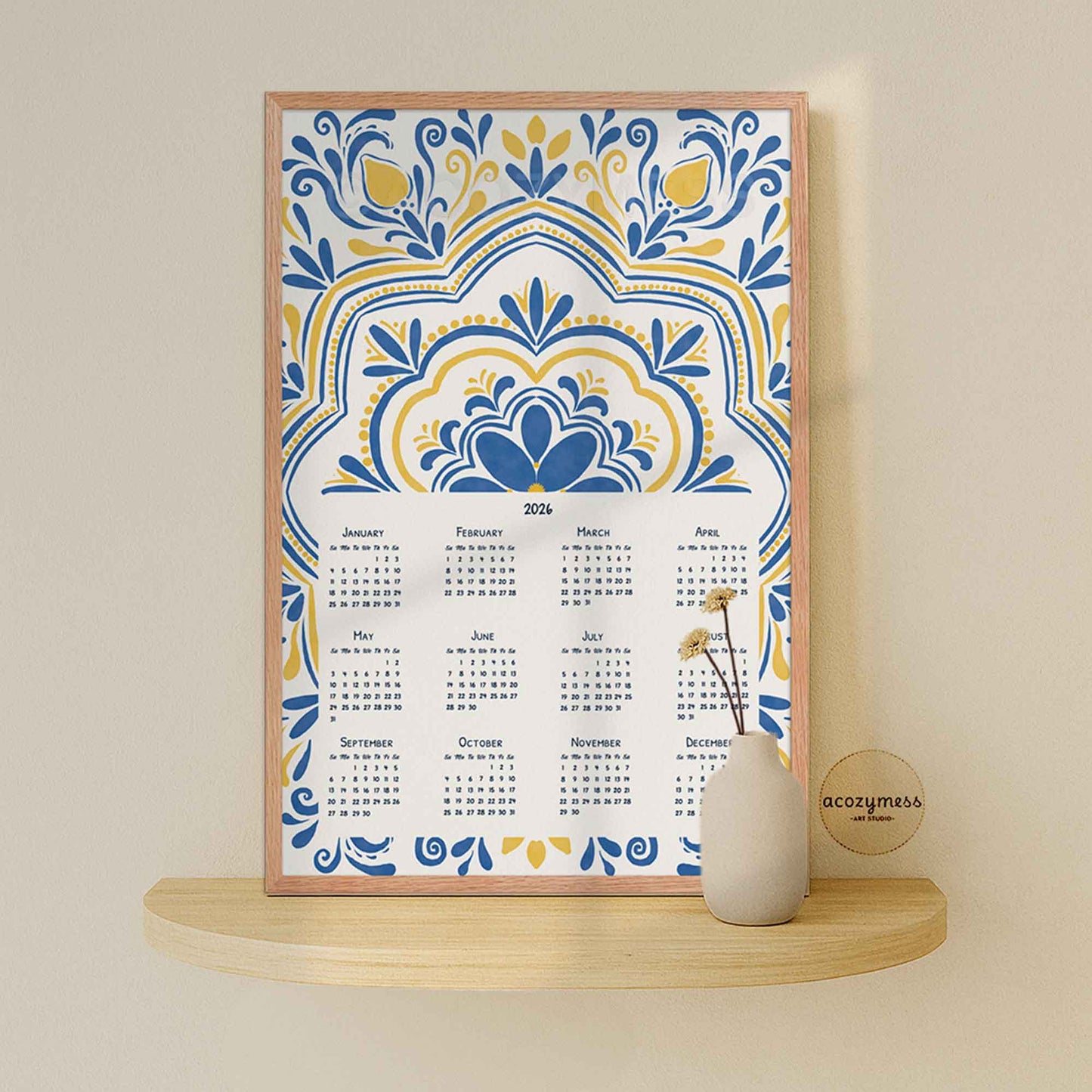 2026 yearly calendar with floral patterns in blue and yellow against white on a shelf against a beige wall