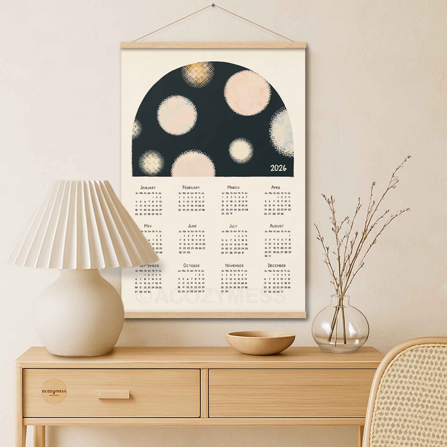 Framed calendar with abstract design on a wall above a wooden console table.