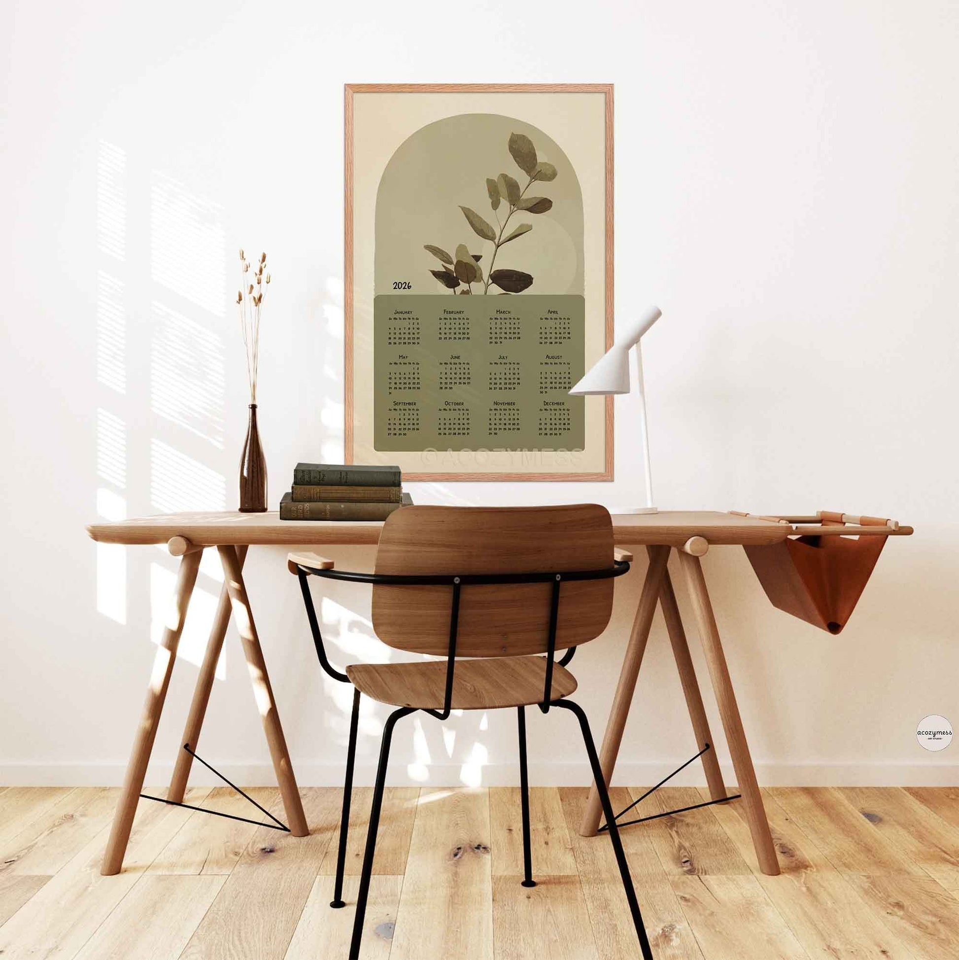 One page calendar 2026 with nature inspired art in green and beige displayed above a desk in office.