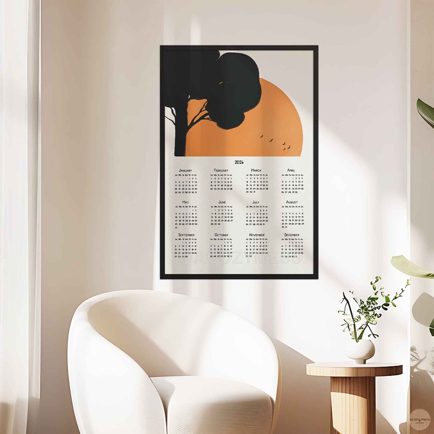 Framed calendar with tree and sun design on a wall.