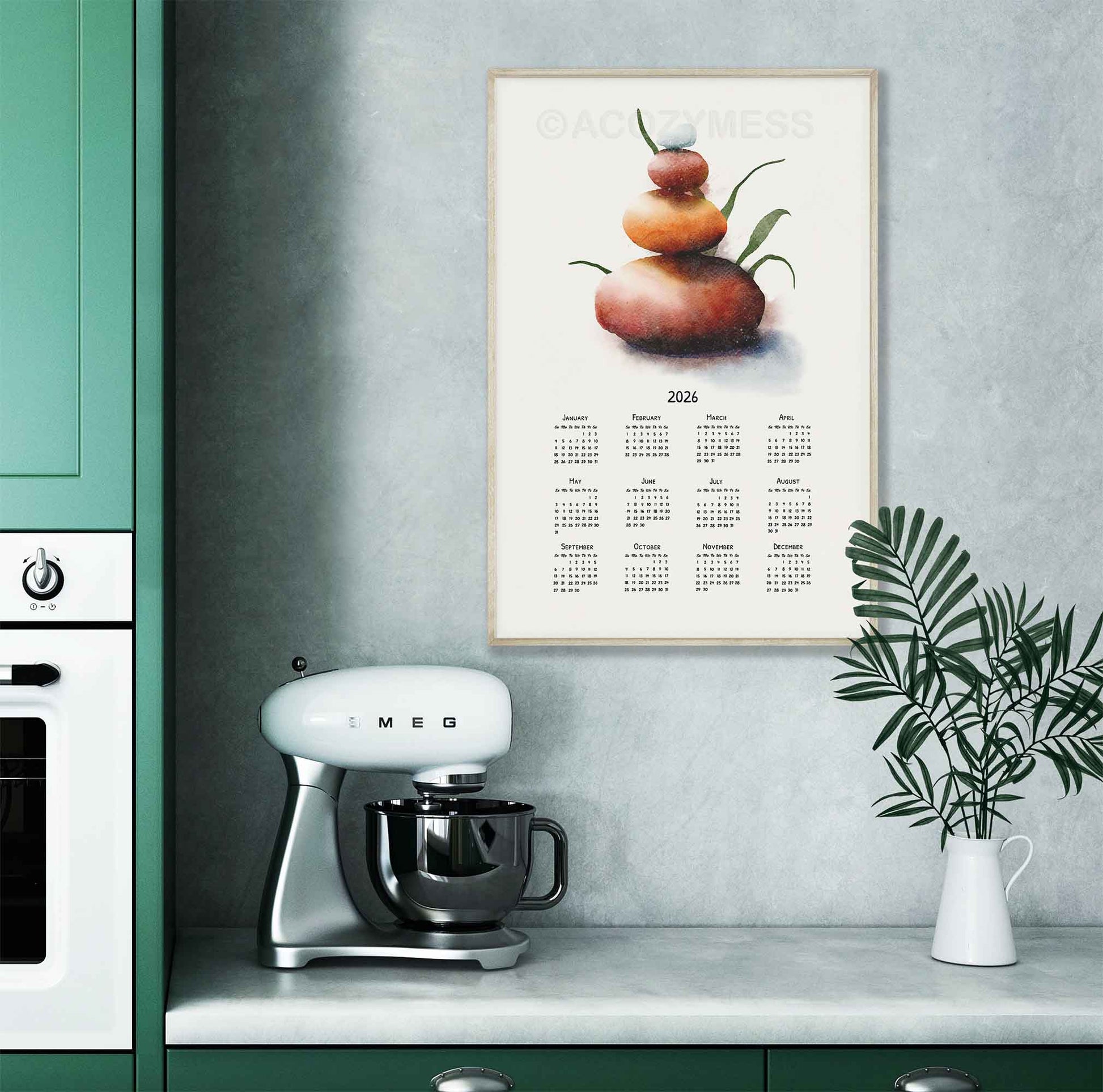 2026 calendar with balancing stones art displayed in wooden frame displayed on a kitchen wall.
