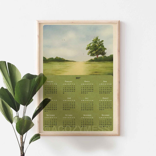 Light wood framed 2027 green meadow calendar on a white wall beside a large green plant