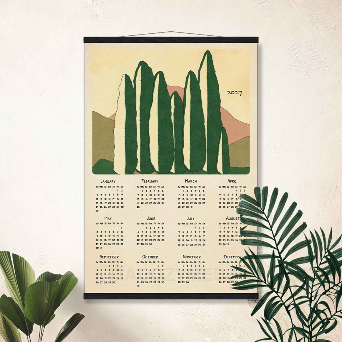 2027 cypress trees calendar poster in a black hanger frame on a white wall with palm leaves