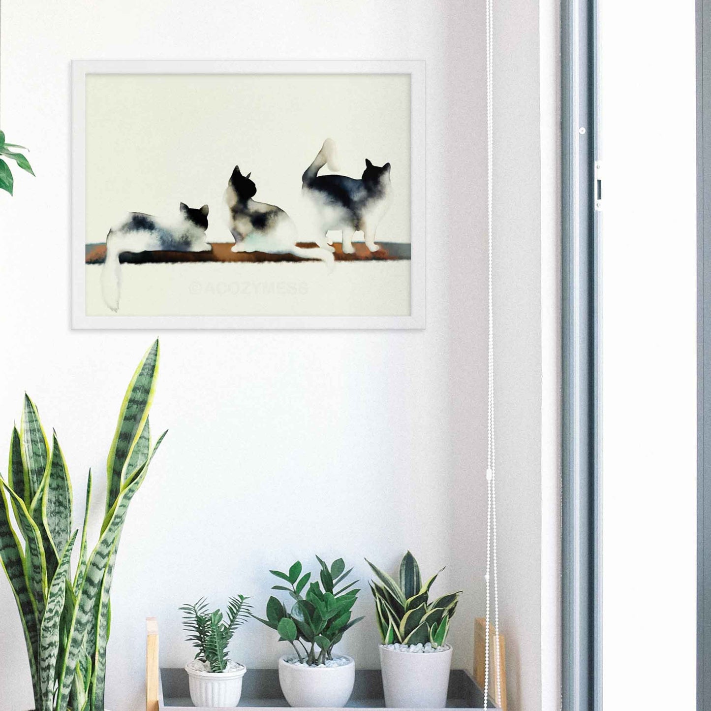 Art print of three cats in black and white with subtle hints of color, capturing a minimalist and elegant aesthetic in white frame