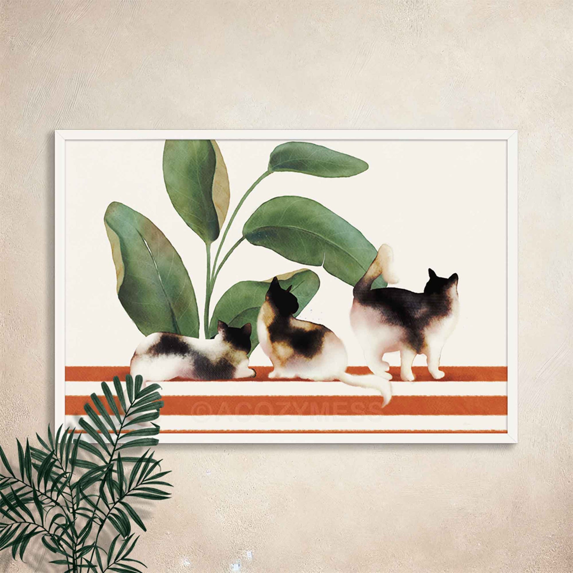 White Framed artwork of three cats on a striped surface with plants  background.