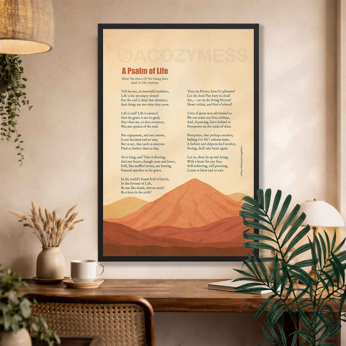 Black framed A Psalm of Life poem print with terracotta desert mountains above a rustic desk with dried flowers and plants