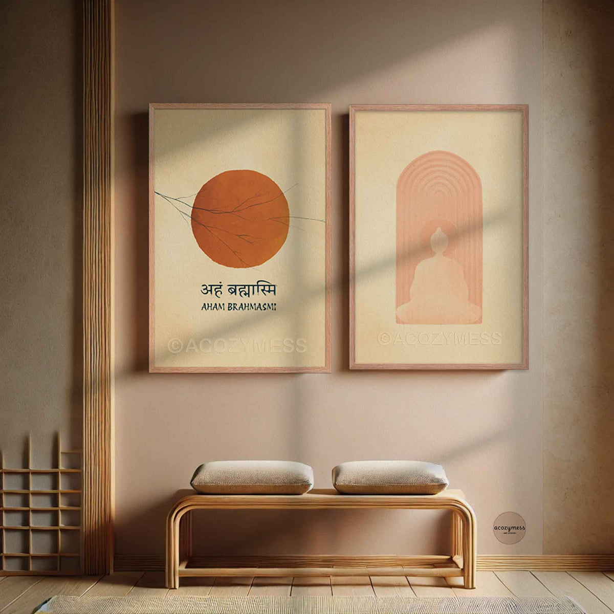 Two minimalist framed wall art prints hang above a wooden bench. The left print shows an orange sun with Devanagari text, and the right print shows a seated figure buddha inside peach arch lines.