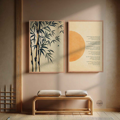 Two framed wall art prints hang above a wooden bench. The left print shows dark bamboo branches on a warm beige background, and the right print features a large orange sun and amazing grace on a cream background.
