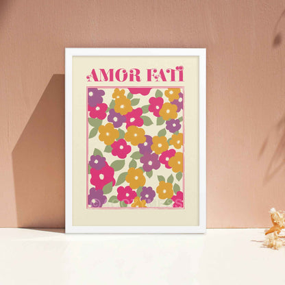 "Amor Fati Abstract Floral Design Art Poster featuring vibrant pink, purple, yellow, and green hues in an abstract floral arrangement on a light beige background, with the phrase 'Amor Fati' meaning 'love of one's fate' integrated into the design." in white frame