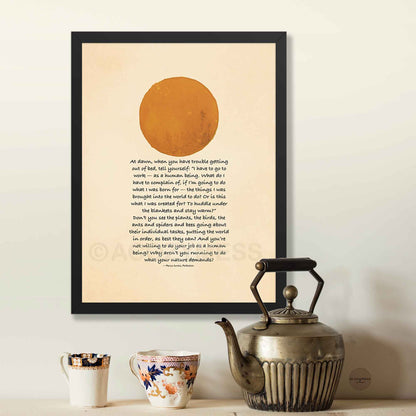Framed artwork with a sun illustration and Inspirational quote on a wall above a teapot and mugs.