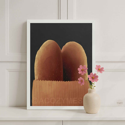 White-framed warm and cozy baguette wall art showing two baguettes in a brown paper bag on a dark gray background.