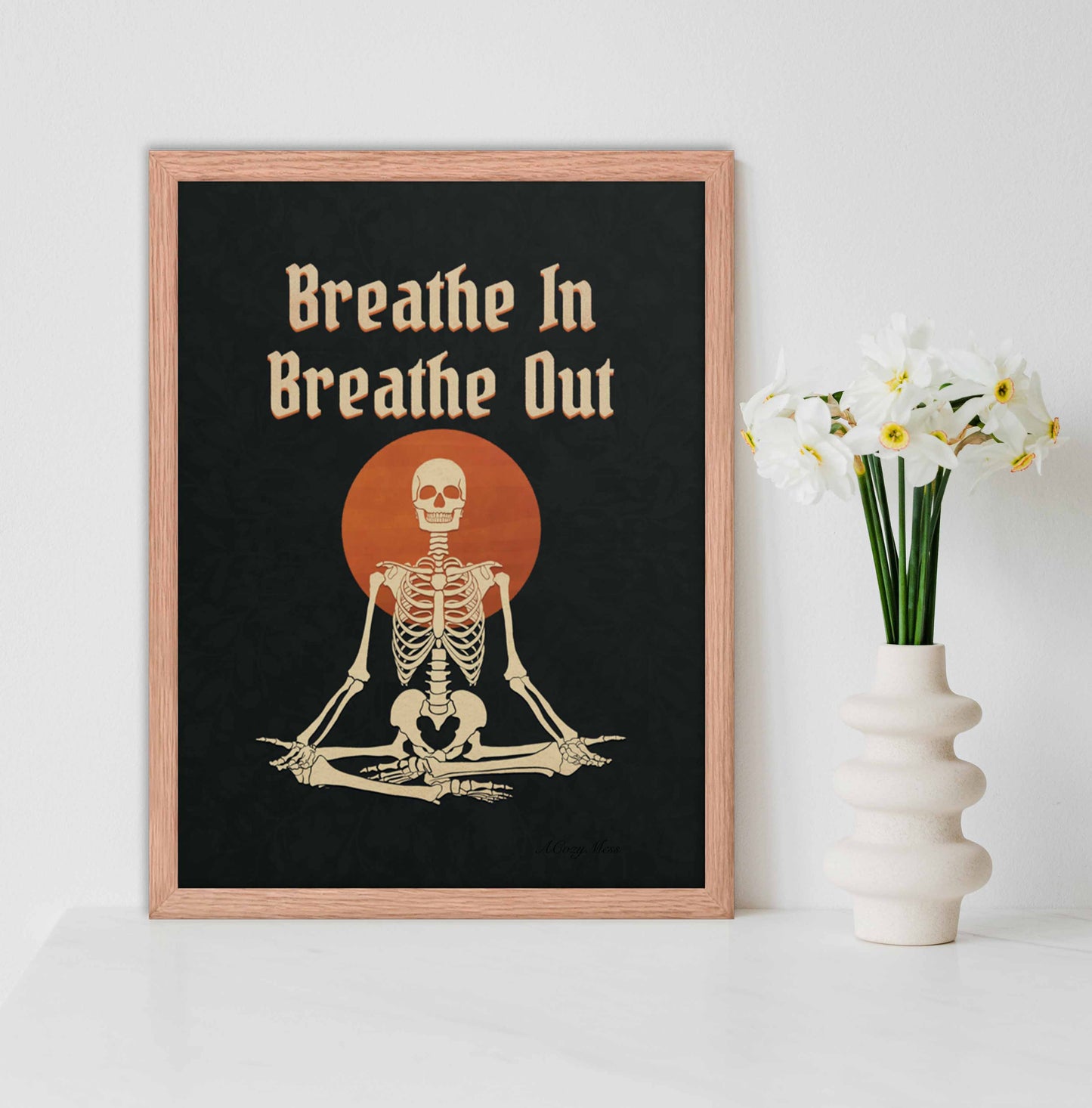 Oak Framed wall art of " Breathe in breathe Out" with an illustration of a meditating skeleton