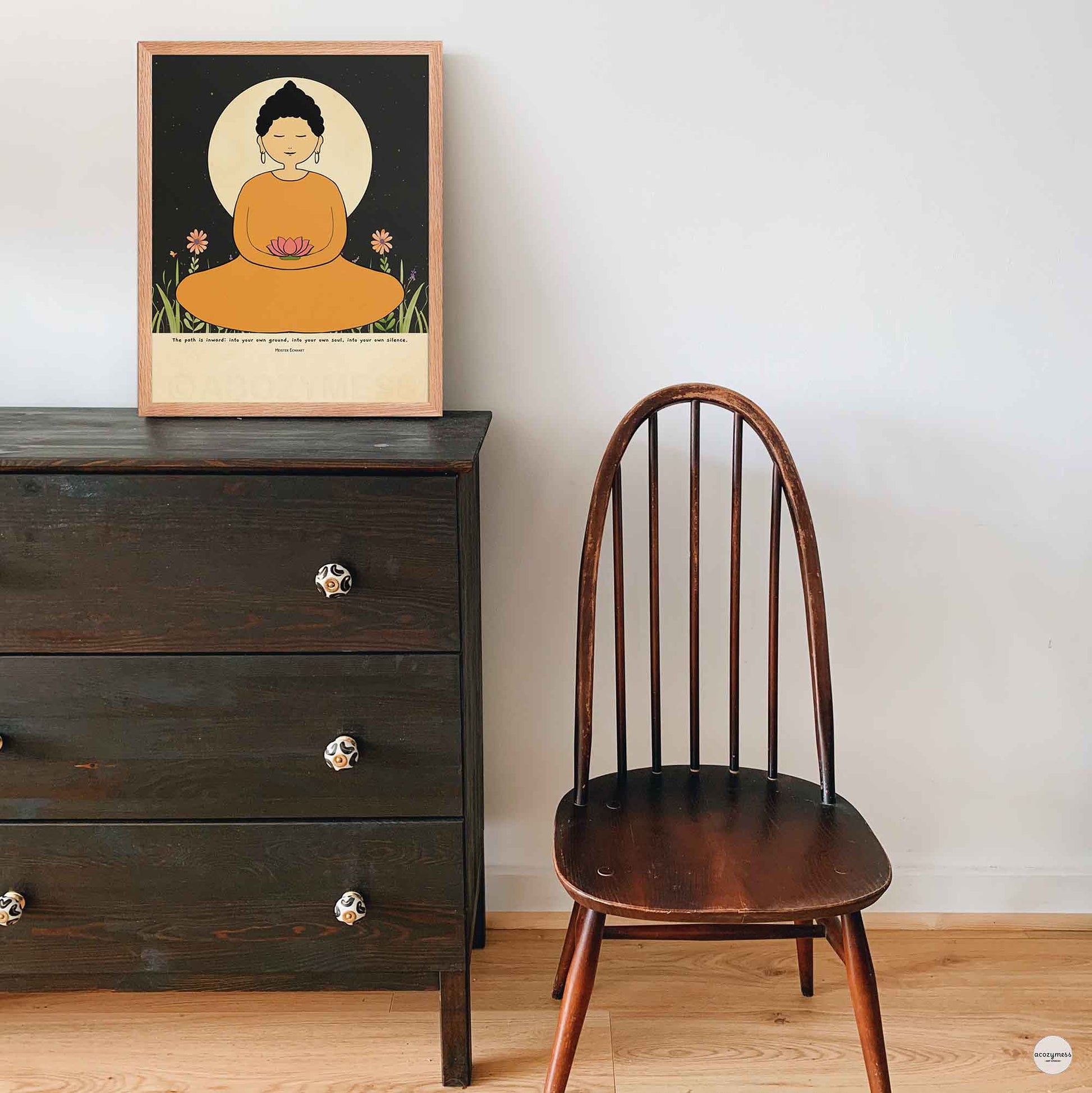  A woman Buddha in a yellow robe meditating, holding a lotus flower. She is seated before a large glowing moon with a starry night sky in the background. The poster includes the quote by Meister Eckhart in oakwood frame for spiritual spaces