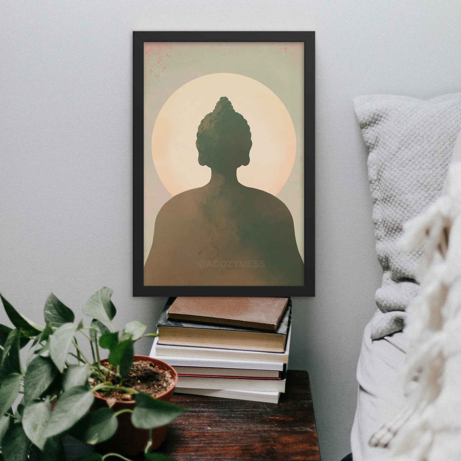 Buddha wall art in earthy tones of blue, green, brown, and beige, designed to bring tranquility and spiritual serenity to any space, in black frame.