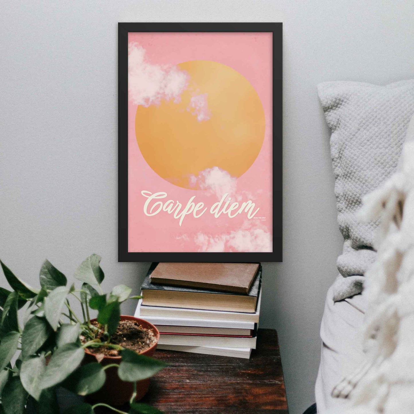 "Carpe Diem poster featuring a pink sky with soft clouds and a bright yellow sun, designed to inspire and uplift with the message 'Seize the Day.'" in black frame