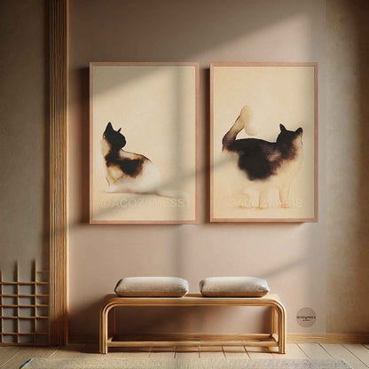 Two oak framed minimalist watercolor cat prints hung as a set above a wooden bench in a calm entryway