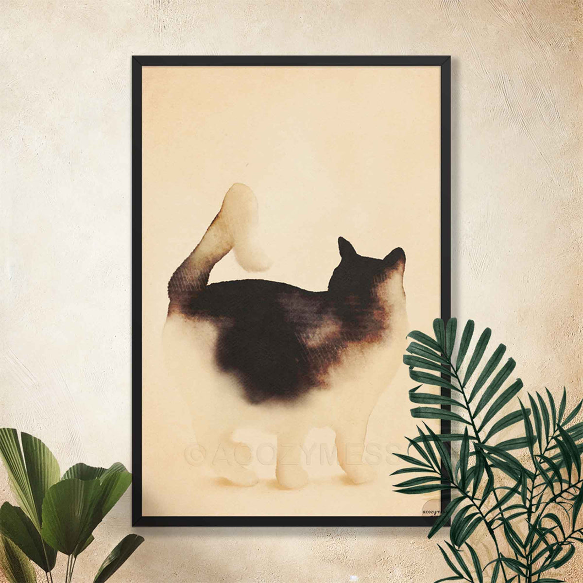 Black framed minimalist cat art print on a textured cream wall with tropical leaves