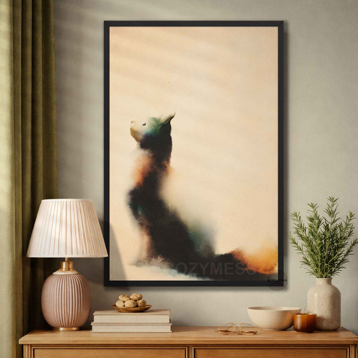 Black framed sitting cat wall art above a wooden sideboard with a pink lamp, books and a potted plant