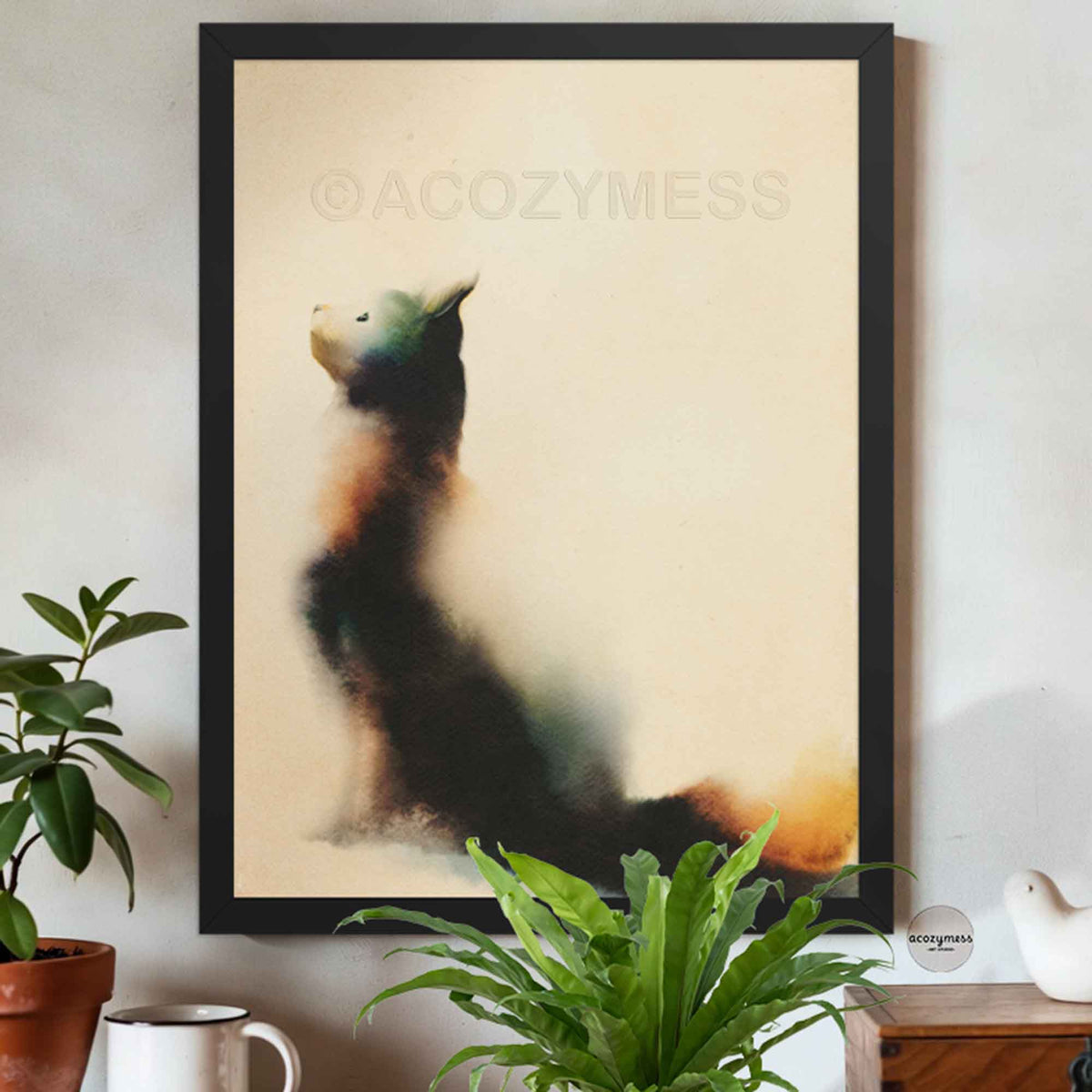 Black framed minimalist cat looking up print on a cream wall above potted plants