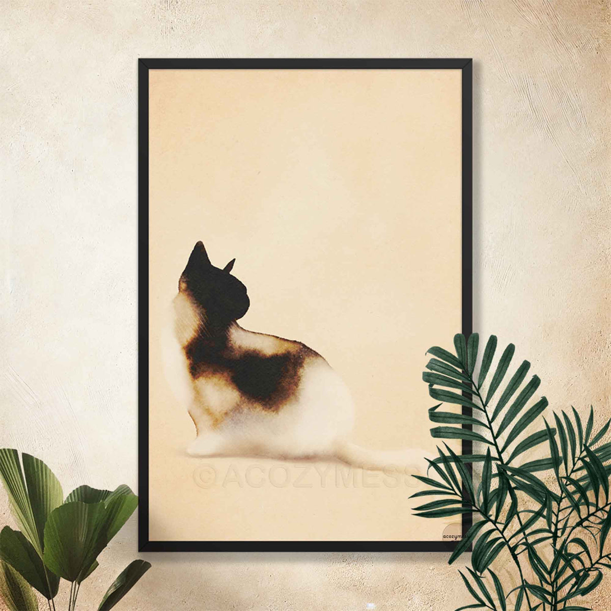 Black framed minimalist cat wall art on a cream wall with tropical plants