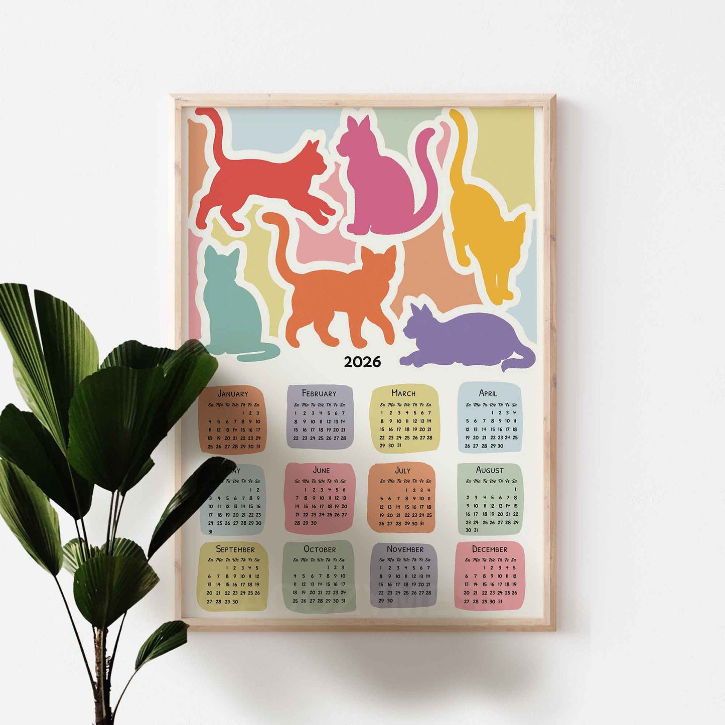 2026 calendar with colorful cat illustrations on a white wall.