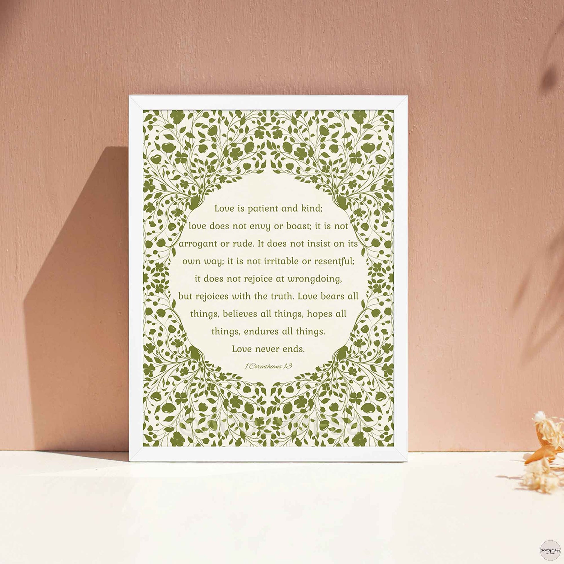 Christian scripture poster framed in white, showcasing the quote “Love is patient, love is kind” with a green floral motif on a light beige background for a fresh, minimalist look.