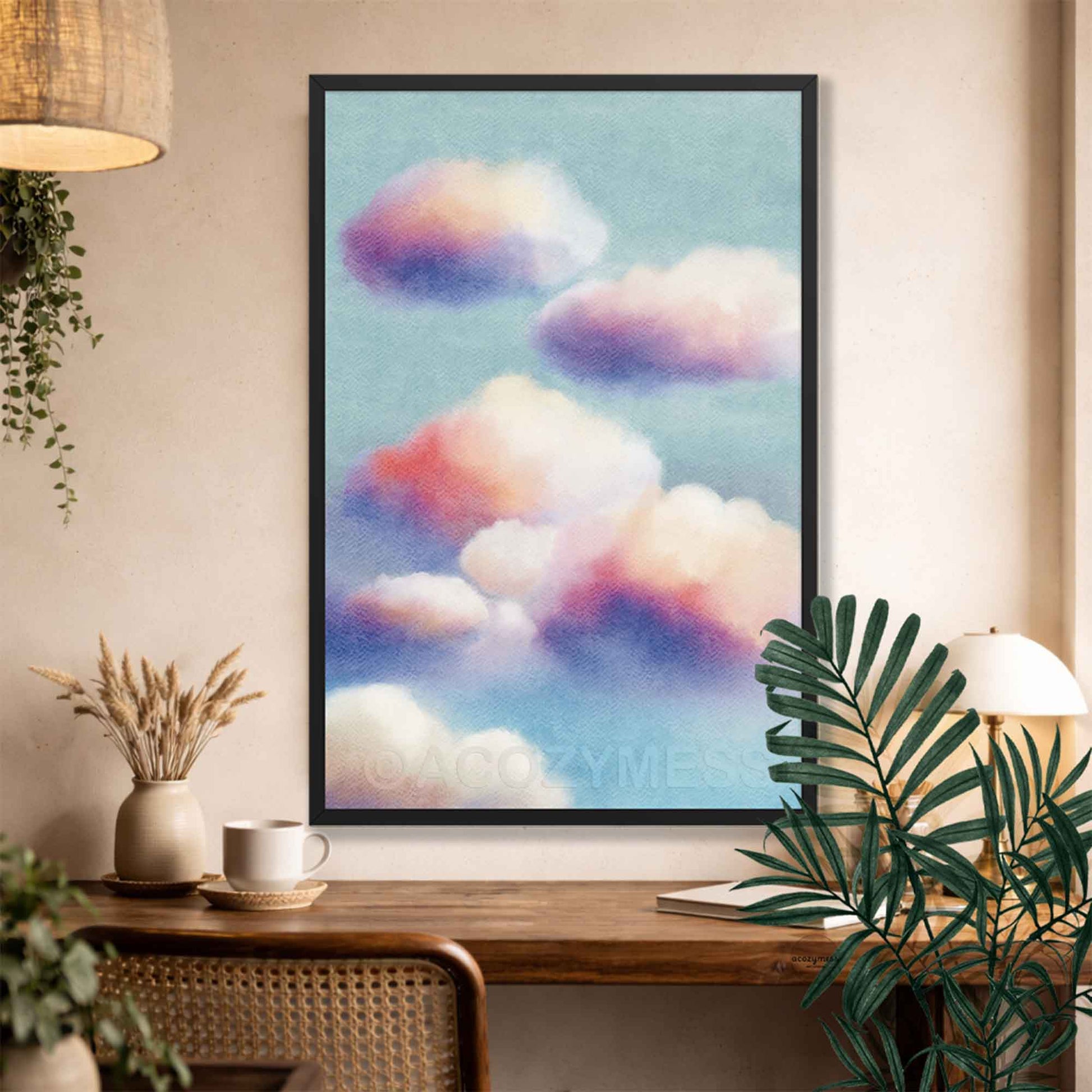 Black Framed artwork of colorful clouds on a wall above a wooden console table with plants.
