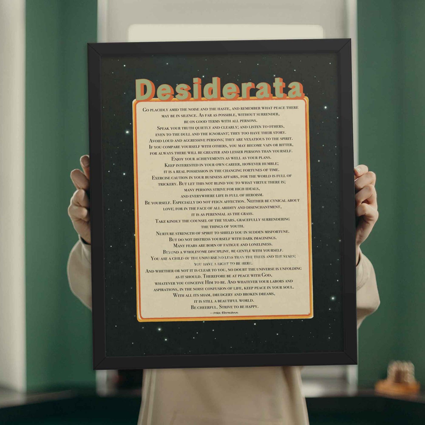 Desiderata poem poster in beige, black, green and orange colors, in black frame.