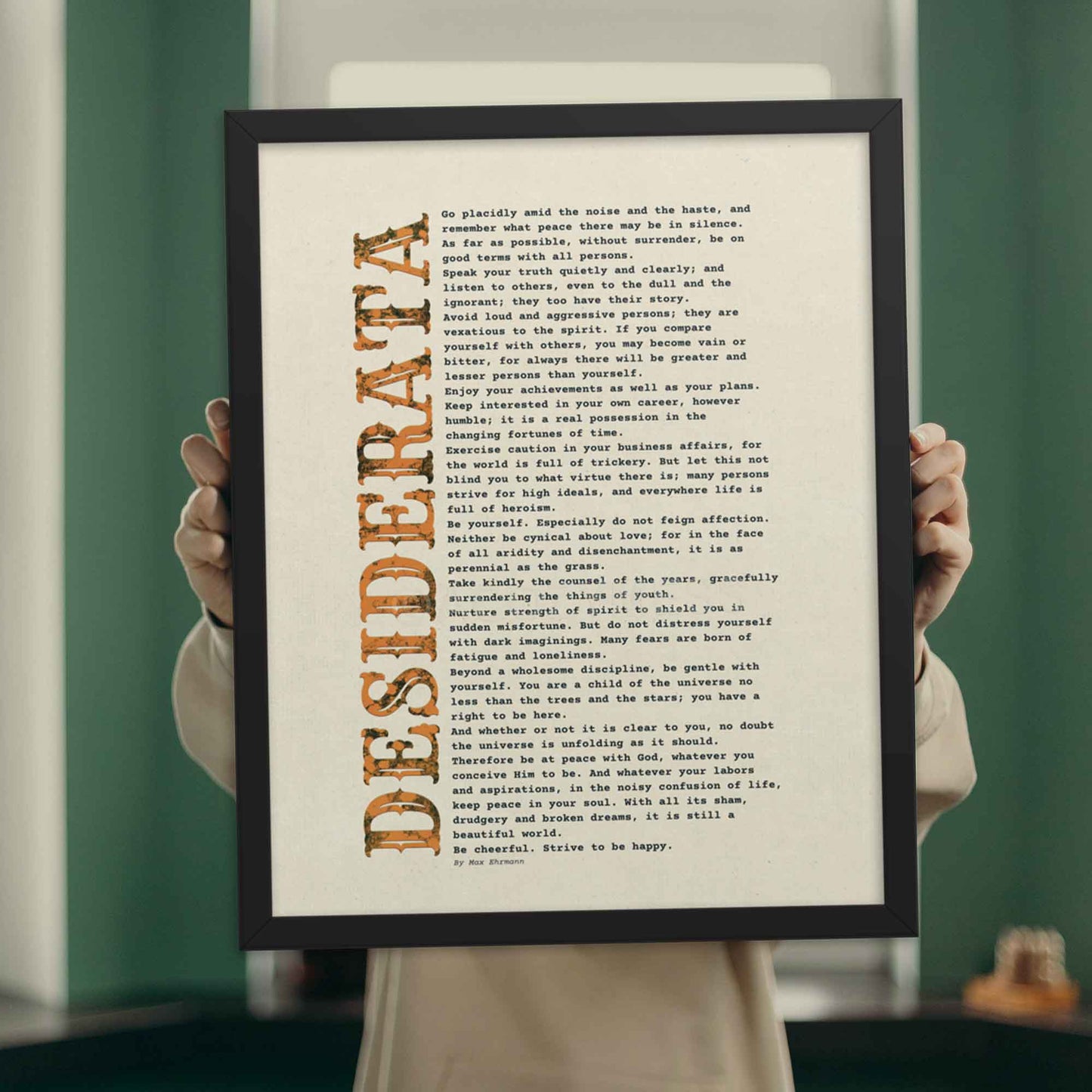 desiderata Poem print black and orange on beige, displayed in black frame.