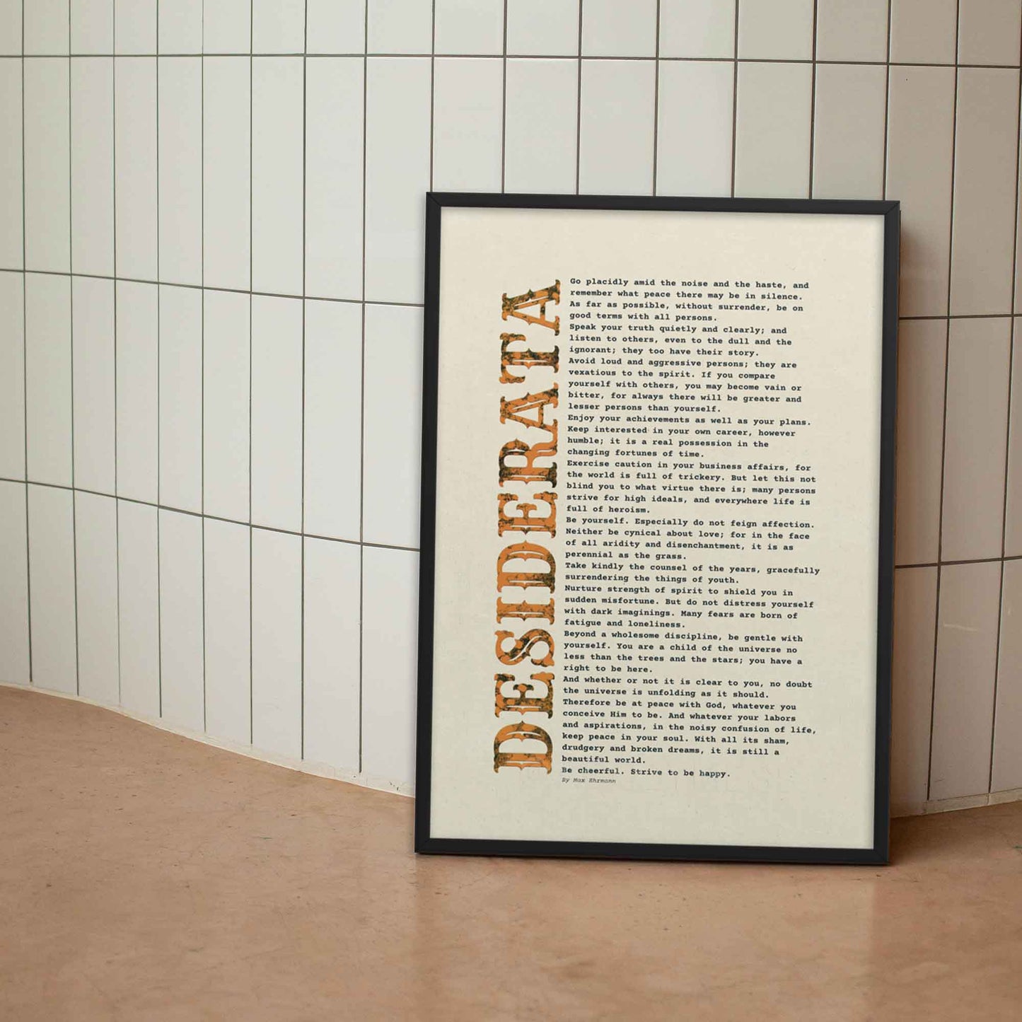 desiderata Poem Poster black and orange on beige, displayed in black frame.