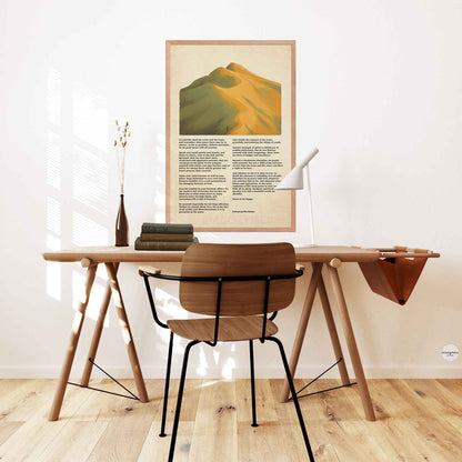 Desiderata poem poster with mountains landscape artwork in earthly green and yellow colors  in oakwood frame hung above a study or office desk