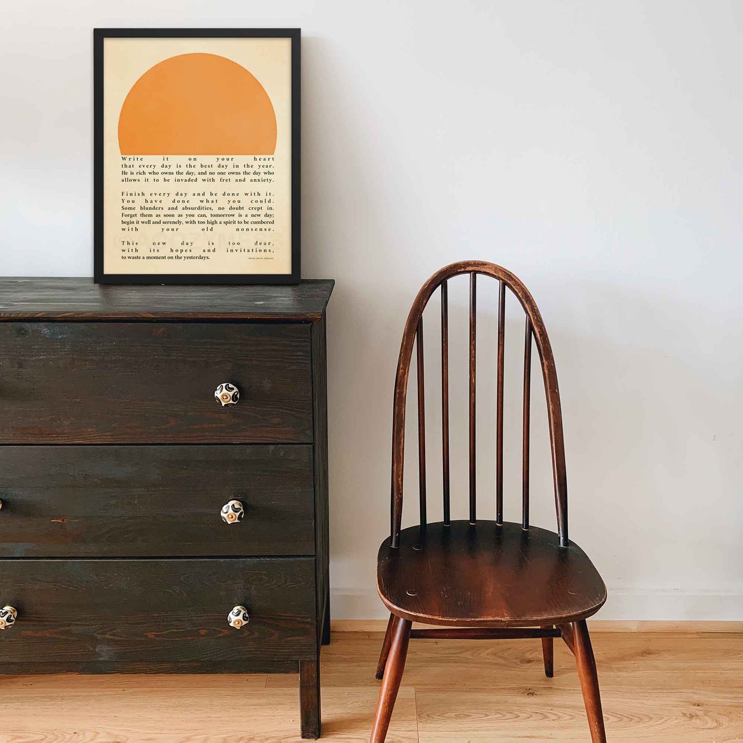 Poster featuring Ralph Waldo Emerson's inspirational quote 'Write it on your heart...' with a warm sun illustration, displayed in a black frame.